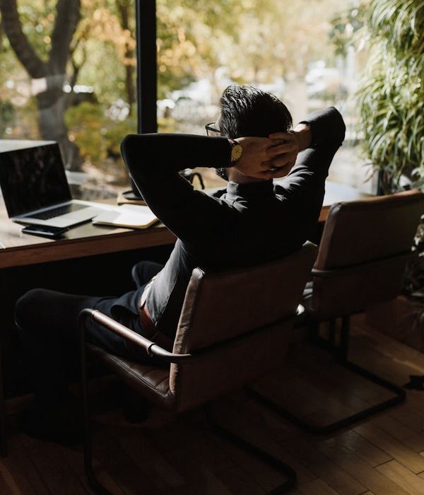 Man stretching his back after working at a desk.